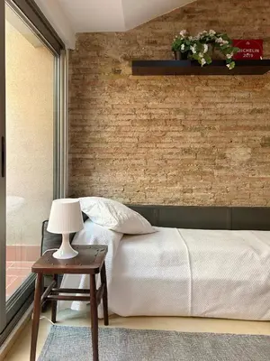 a bedroom with a bed and a brick wall at SF Apartamento céntrico con terraza in Terrassa