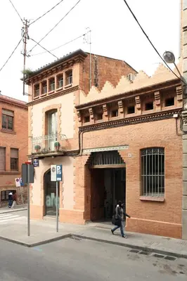 a person walking in front of a brick building at SF Apartamento céntrico con terraza in Terrassa
