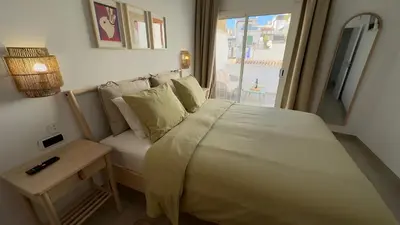 a bedroom with a bed with a table and a window at Penthouse in Historic Sitges -Big Terrace & Private Solarium in Sitges
