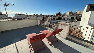 two red chairs and a table on a balcony at Penthouse in Historic Sitges -Big Terrace & Private Solarium in Sitges