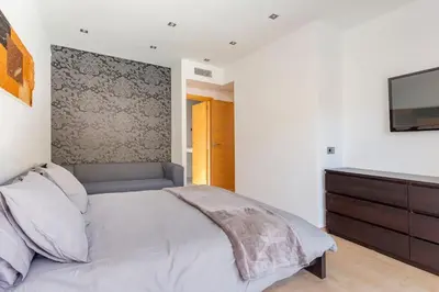 a bedroom with a bed and a tv on a wall at Exclusiva Villa de Lujo con piscina in Canyelles