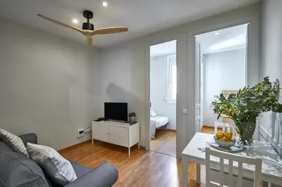 a living room with a couch and a table with a television at BBarcelona Montjuic Apartment in Barcelona