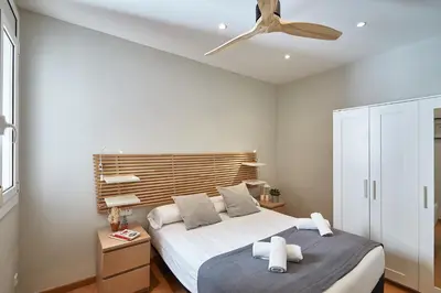 a bedroom with a bed and a ceiling fan at BBarcelona Montjuic Apartment in Barcelona