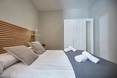a bedroom with a large white bed with two pillows at BBarcelona Montjuic Apartment in Barcelona