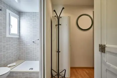 a bathroom with a tub and a toilet and a mirror at BBarcelona Montjuic Apartment in Barcelona