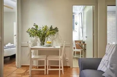 a dining room table with a vase of flowers on it at BBarcelona Montjuic Apartment in Barcelona