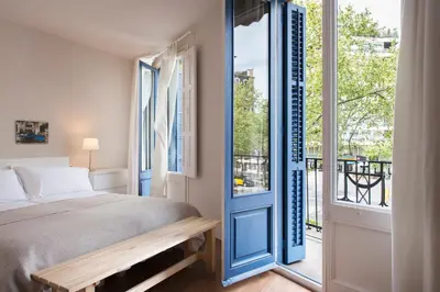 a bedroom with a bed and a door to a balcony at Bed&BCN Diagonal 2 in Barcelona