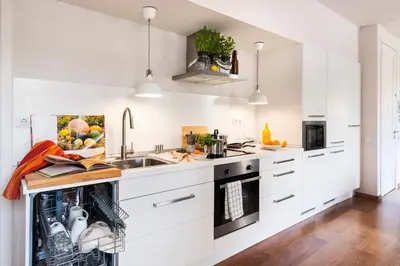 a kitchen with white cabinets and a sink at Bed&BCN Diagonal 2 in Barcelona