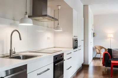 a white kitchen with a sink and a stove at Bed&BCN Diagonal 2 in Barcelona