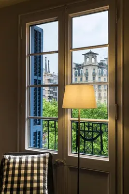a lamp next to a window with a view of a building at Bed&BCN Diagonal 4 in Barcelona