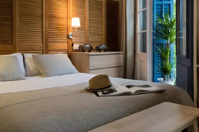 a bed with a hat and a book on it at Bed&BCN Diagonal 4 in Barcelona