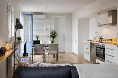 a kitchen and living room with a couch and a table at Bed&BCN Diagonal 5 in Barcelona