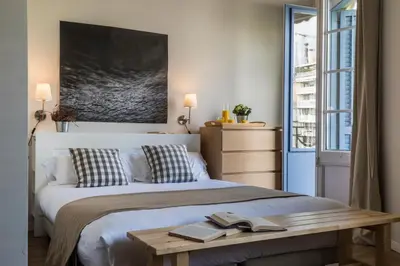 a bedroom with a large bed with two books on it at Bed&BCN Diagonal 5 in Barcelona