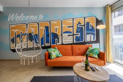 a living room with a orange couch and a mural at oasis en el centro de manresa in Manresa