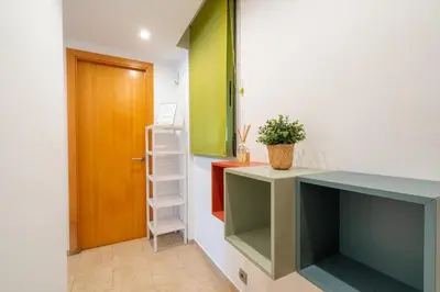 a room with a desk with a shelf and a door at oasis en el centro de manresa in Manresa