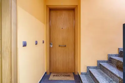 a wooden door in a building with stairs at oasis en el centro de manresa in Manresa
