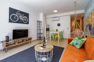 a living room with an orange couch and a tv at oasis en el centro de manresa in Manresa