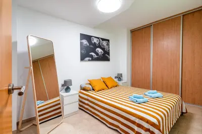 a bedroom with a bed with orange pillows and a mirror at oasis en el centro de manresa in Manresa