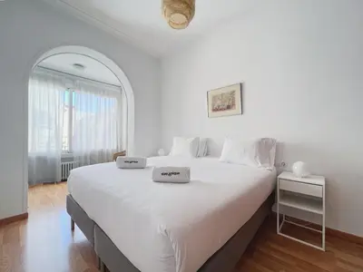 a white bedroom with a large white bed and a window at Stay U-nique Apartment Passeig de Gràcia III in Barcelona