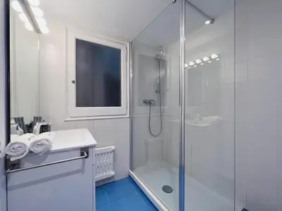 a white bathroom with a shower and a sink at Stay U-nique Apartment Passeig de Gràcia III in Barcelona