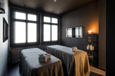 a room with two beds and two windows at Grand Hotel Central, Small Luxury Hotels in Barcelona