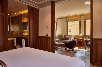 a bedroom with a bed and a living room at Grand Hotel Central, Small Luxury Hotels in Barcelona