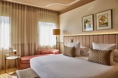 a hotel room with a large bed and a chair at Grand Hotel Central, Small Luxury Hotels in Barcelona