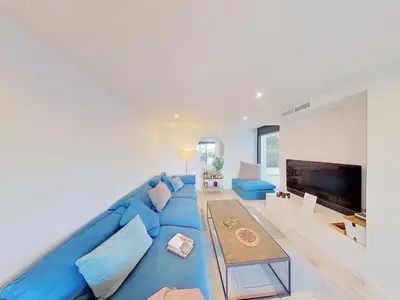 a blue couch in a living room with a tv at Premium Habitat 3 Hermanas in Sant Andreu de Llavaneres