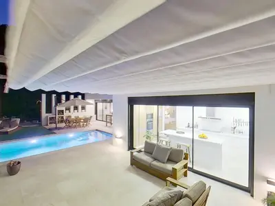 a living room with a couch and a swimming pool at Premium Habitat 3 Hermanas in Sant Andreu de Llavaneres