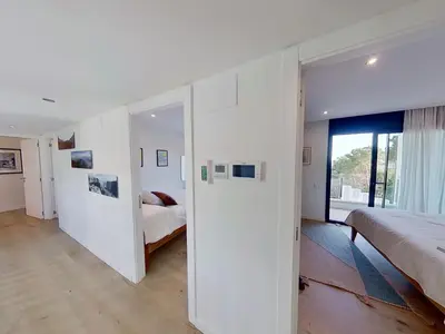 a white bedroom with two beds and a window at Premium Habitat 3 Hermanas in Sant Andreu de Llavaneres