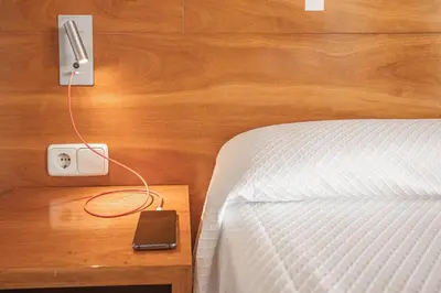 a bedroom with a bed and a phone on a night stand at Can Fisa Hotel & Apartments in Corbera de Llobregat