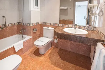 a bathroom with a toilet and a sink at Can Fisa Hotel & Apartments in Corbera de Llobregat