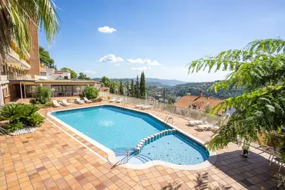 a swimming pool with a view of the mountains at Can Fisa Hotel & Apartments in Corbera de Llobregat