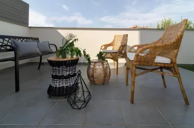 a patio with two chairs and a table and some plants at Sitges Spaces Sea View Oasis in Sitges