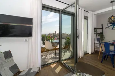 a living room with sliding glass doors leading to a balcony at Sitges Spaces Sea View Oasis in Sitges