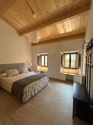 a bedroom with a large bed and two windows at CasaBala - Near the beach and Barcelona center in Badalona
