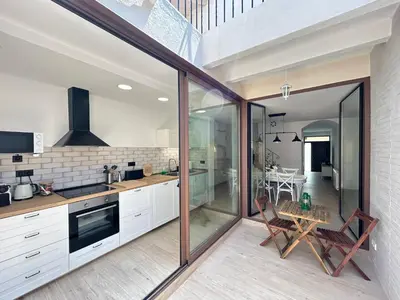 a kitchen with glass doors and a table with chairs at CasaBala - Near the beach and Barcelona center in Badalona