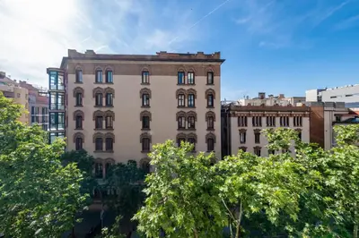 a living room with a white couch and green chairs at BeBarceloner Eixample Apartments - 4 bedrooms in Barcelona