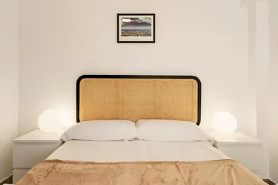 a bedroom with a bed with two lamps on it at Apartamento cerca de la playa in Barcelona