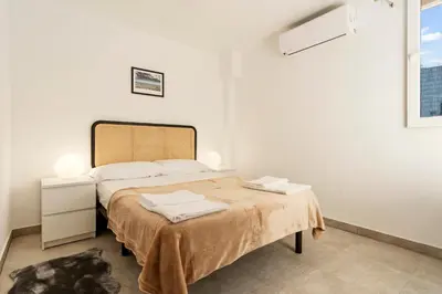 a white bedroom with a large bed in a room at Apartamento cerca de la playa in Barcelona