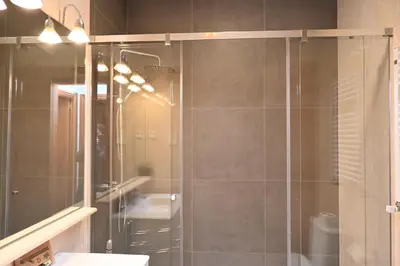 a bathroom with a glass shower with a sink at Homenfun Barcelona Las Ramblas in Barcelona