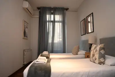 a hotel room with two beds and a window at Homenfun Barcelona Las Ramblas in Barcelona