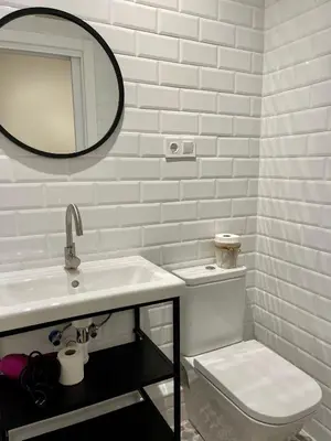 a white bathroom with a sink and a toilet at Barcelona PR Guesthouse in El Prat de Llobregat