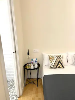 a bedroom with a bed and a table with drinks on it at Barcelona PR Guesthouse in El Prat de Llobregat