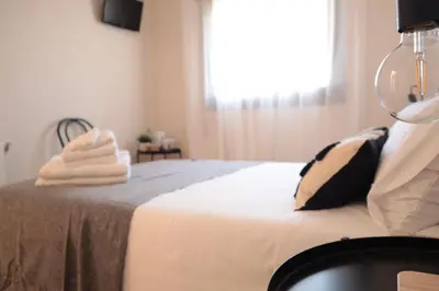 a bedroom with a bed with towels on it at Barcelona PR Guesthouse in El Prat de Llobregat