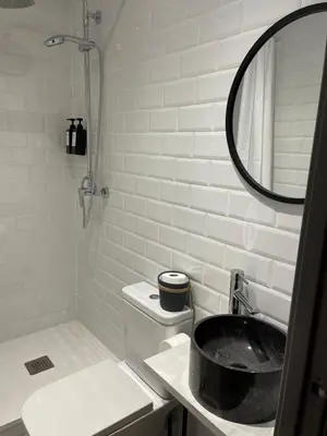 a bathroom with a sink and a toilet and a mirror at Barcelona PR Guesthouse in El Prat de Llobregat
