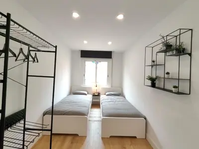 a room with three beds and a window at Fantastic apartment Sant Adria Beach in Sant Adria de Besos