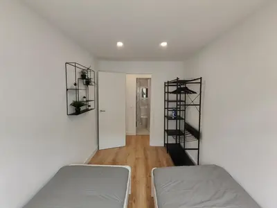 a white room with two beds and a staircase at Fantastic apartment Sant Adria Beach in Sant Adria de Besos