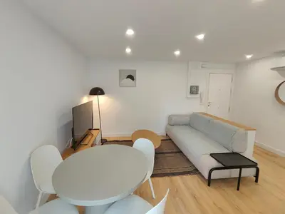 a living room with a couch and a table and chairs at Fantastic apartment Sant Adria Beach in Sant Adria de Besos