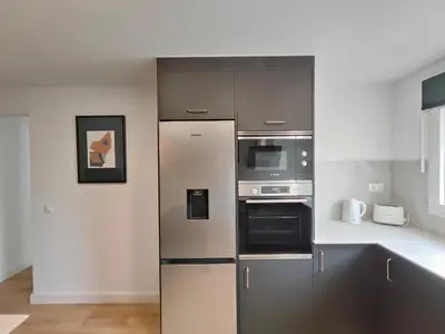 a kitchen with a refrigerator and a microwave at Fantastic apartment Sant Adria Beach in Sant Adria de Besos